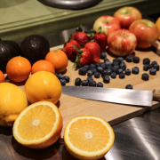 Some fruits and a knife on a cutting board