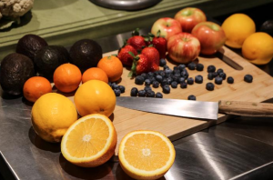 Some fruits and a knife on a cutting board