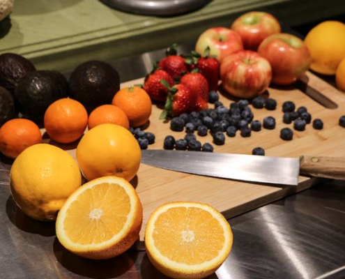 Some fruits and a knife on a cutting board