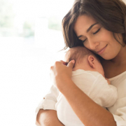 Pretty woman holding a newborn baby in her arms.