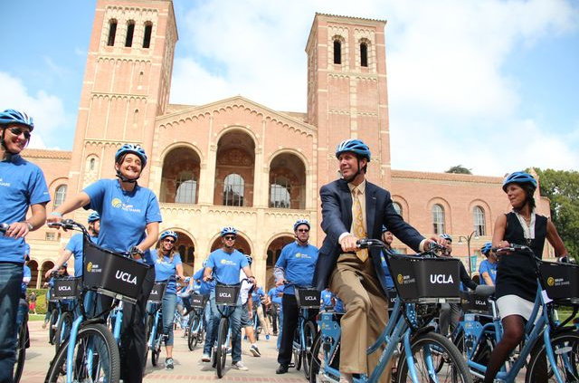 A group of people biking on campus using the ucla bikes