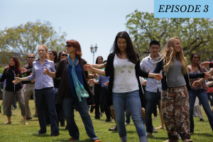 A group of people dancing outside on the grass