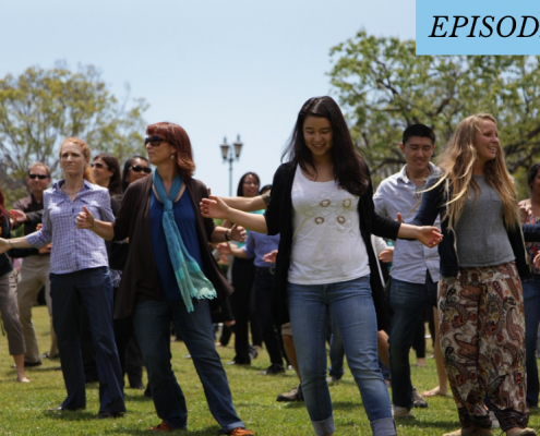 A group of people dancing outside on the grass