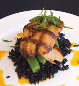 Fish on top of some black rice