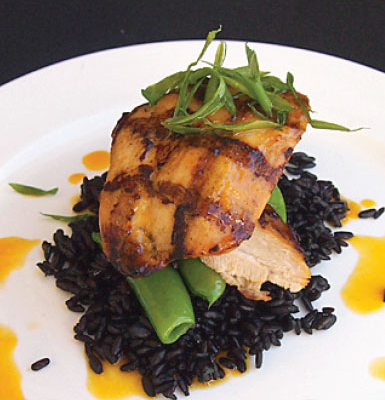 Fish on top of some black rice