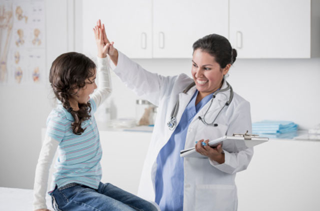 a doctor giving a girl a high five during her doctor visit