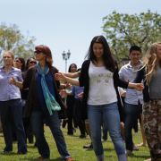 A group of people dancing on grass outside