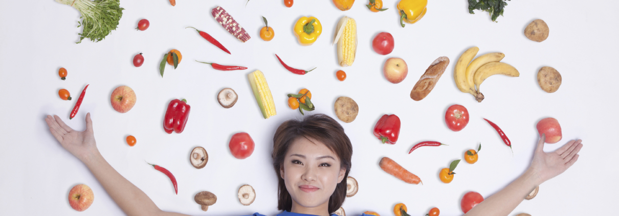 a woman with veggies surrounding her in a picture