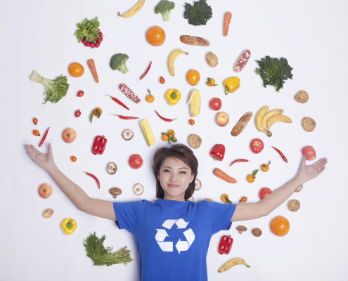 a woman with veggies surrounding her in a picture