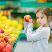 a girl holding a red apple