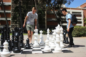 2 students playing chess outside