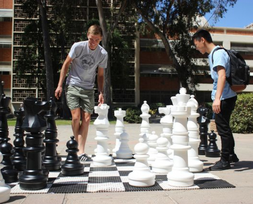 2 students playing chess outside