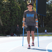 Person with crutches walking around Drake Stadium