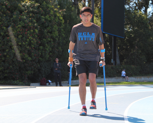 Person with crutches walking around Drake Stadium