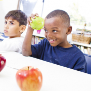 a kid holding a green apple