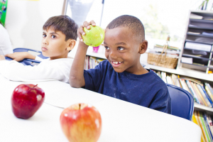 a kid holding a green apple