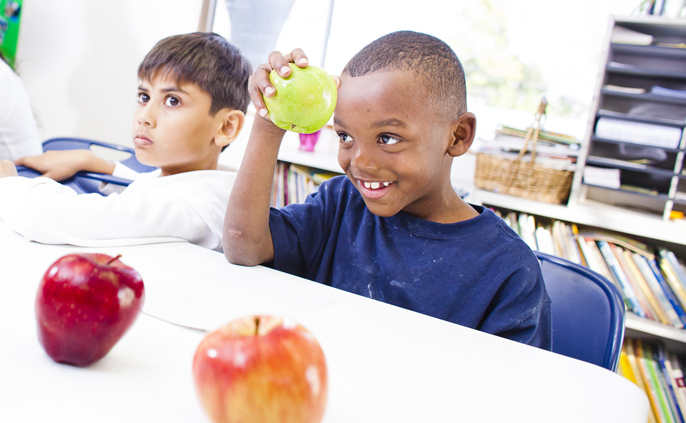 a kid holding a green apple