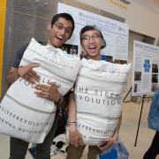 two students holding pillows posing for a picture