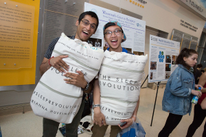 two students holding pillows posing for a picture