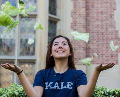 A girl throwing some pieces of cabbage in the air