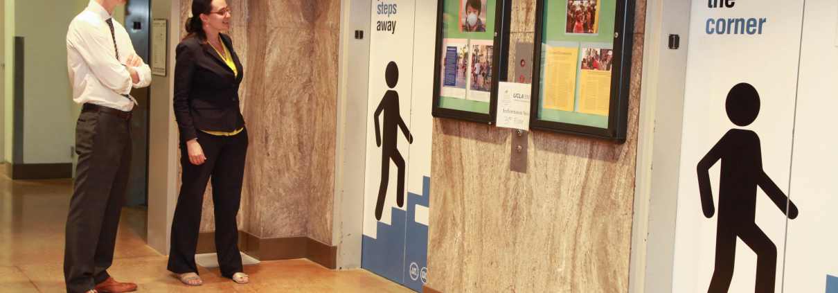 A man and a woman standing in front of the elevators