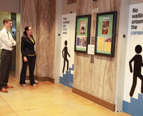 A man and a woman standing in front of the elevators