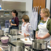 4 women at the UCLA test kitchen listening to a woman instructor teach a cooking class